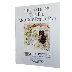 Könnte beinhalten: Die Geschichte vom Kuchen und der Pastetenform von Beatrix Potter, die Original- und autorisierte Ausgabe mit neuen Farbreproduktionen. Das Cover zeigt einen schwarzen Hund, der einen Blumenstrauß hält.