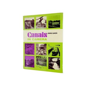 May include: A green book cover with the title "Canals in Camera" and the author "John Gagg". The cover features nine black and white photos of canals and boats.