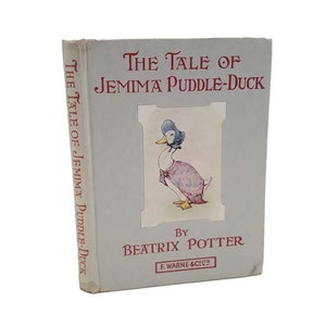 Puede incluir: Una portada de libro vintage con un pato azul claro que lleva un vestido rosa y un gorro azul. El título del libro es "The Tale of Jemima Puddle-Duck" de Beatrix Potter.