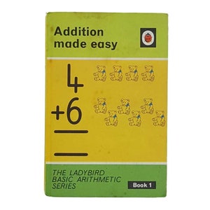 May include: A green and yellow book titled "Addition made easy" with a ladybug logo. The book features a math problem with teddy bears illustrating the sum of 4 + 6. The book is part of "The Ladybird Basic Arithmetic Series" and is labeled "Book 1".