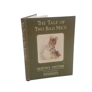 May include: A green book titled "The Tale of Two Bad Mice" by Beatrix Potter. The cover features an illustration of a mouse in a purple dress holding a book.