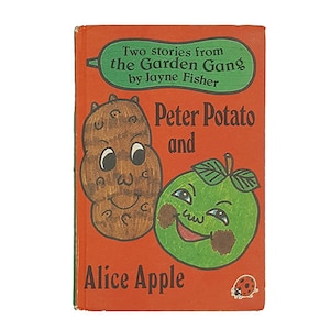 Puede incluir: Una portada de libro roja con el título "Dos historias de la pandilla del jardín por Jayne Fisher" y el subtítulo "Peter Potato y Alice Apple". La portada presenta ilustraciones de una patata y una manzana con caras.