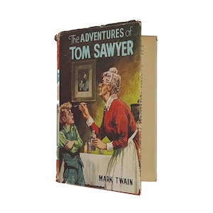 May include: A vintage book cover featuring an illustration of a woman giving a boy medicine. The book title is "The Adventures of Tom Sawyer" by Mark Twain.
