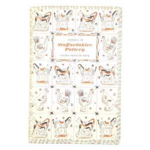Könnte beinhalten: Ein Vintage-Buchcover mit dem Titel "Animals in Staffordshire Pottery" von A King Penguin Book. Das Cover zeigt ein Rastermuster mit Illustrationen von Tierfiguren in Weiß, Braun und Orange auf cremefarbenem Hintergrund.
