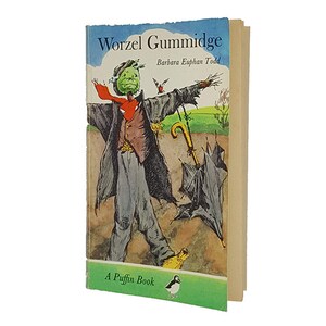 Puede incluir: Una portada de libro de bolsillo vintage con un personaje de espantapájaros verde llamado Worzel Gummidge. El libro se titula "Worzel Gummidge" de Barbara Euphan Todd y es un libro Puffin.