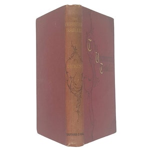 Pode incluir: Um livro encadernado em vermelho com letras douradas na lombada e na capa. O título é "The Uncommercial Traveller" de Charles Dickens. O livro é publicado por Chapman and Hall.