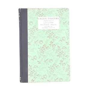 May include: A green book with a floral pattern cover. The title "GREEN FINGERS" is printed on the front cover, along with the text "A present for a good gardener". The author is listed as "REGINALD ARKELL" and the illustrator is "EUGENE HASTAIN".