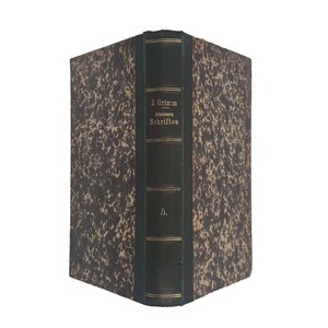 Puede incluir: Un libro antiguo con una cubierta marmoleada marrón y crema. El lomo es verde oscuro con letras doradas que dicen "J. Grimm Kleinere Schriften" y el número "5."