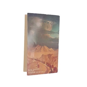 Puede incluir: Una portada de libro de bolsillo de ciencia ficción vintage que presenta un paisaje desértico con un grupo de personas caminando hacia una cordillera. La portada se titula "Astronauts" y tiene una fecha de copyright de 1968.