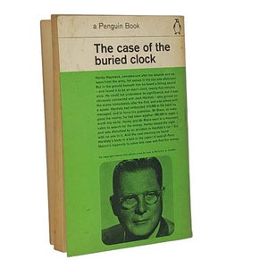 Puede incluir: Un libro de bolsillo Penguin verde con el título "The case of the buried clock" y una imagen de un hombre con gafas en la portada.