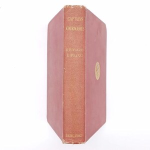 May include: A red hardcover book with the title "Captains Courageous" by Rudyard Kipling. The book is published by Macmillan and Co.