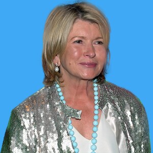 May include: A woman with short blonde hair wearing a silver sequined jacket with a turquoise beaded necklace and pearl earrings.