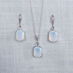 Peut inclure: Un collier et des boucles d'oreilles en argent avec un pendentif rectangulaire en opale blanche et des boucles d'oreilles assorties.
