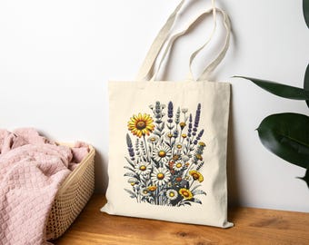 Könnte beinhalten: Cremefarbene Tragetasche mit einem farbenfrohen Blumendesign. Die Illustration zeigt eine große gelbe Sonnenblume, weiße Gänseblümchen und lila Lavendel. Die Tasche hat zwei Griffe und ist aus einem robusten Stoff gefertigt, ideal zum Tragen von Lebensmitteln oder anderen Gegenständen.