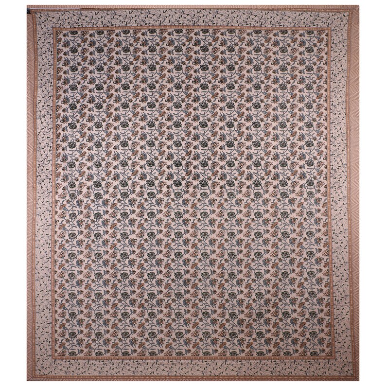 May include: A white cotton fabric with a repeating pattern of small brown and green floral designs. The fabric has a border of a light brown floral pattern.
