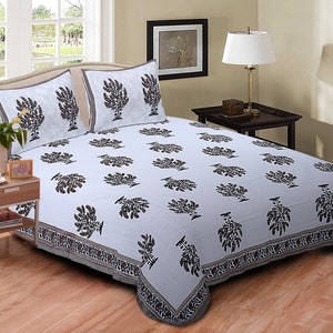 Puede incluir: Sábana de cama de algodón blanco con estampado de árboles negro y marrón. La sábana tiene un borde decorativo con un patrón floral. Se incluyen dos fundas de almohada a juego.