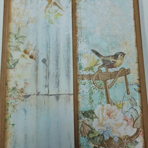 以下が含まれることがあります： 青と白の背景に、錨に止まっている鳥、バラ、ヒトデが描かれたスクラップブッキングペーパー。紙は、茶色の縁取りで、使い古したような風合いになっている。