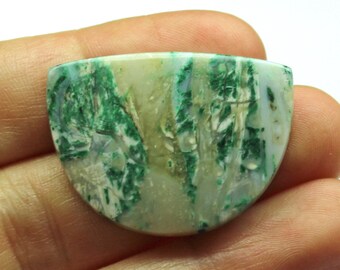 May include: A green and white agate cabochon with a unique pattern. The cabochon is shaped like a half-circle and has a smooth, polished surface.