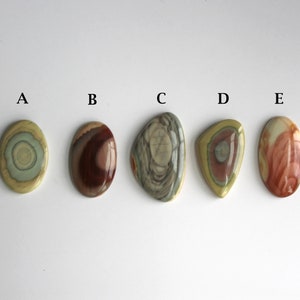May include: Five oval-shaped polished stones with different patterns and colors, labeled A through E.