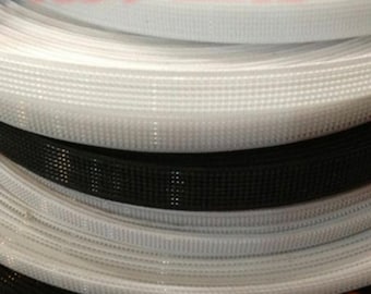 May include: Close-up of white and black hook and loop tape rolls. The tape is made of a woven nylon material with small, evenly spaced holes.