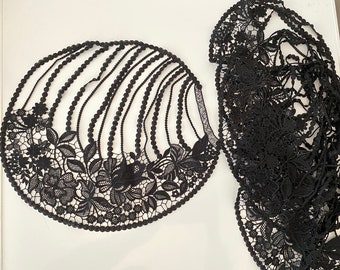 May include: Two pieces of black lace fabric. One piece is a circular shape with a scalloped edge and the other is a more free-flowing shape.