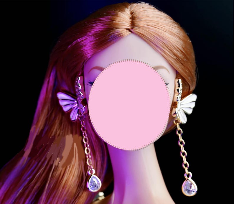 May include: A pair of gold butterfly earrings with clear crystal accents and dangling teardrop crystals.