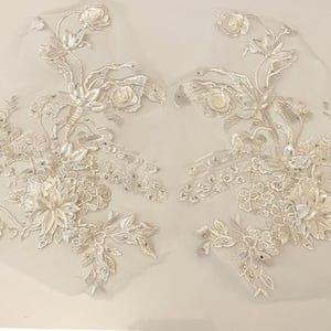 Può includere: Due delicati ricami in pizzo bianco con motivi floreali e decorazioni scintillanti. Questi ricami sono perfetti per aggiungere un tocco di eleganza agli abiti da sposa, agli accessori da sposa o ad altri progetti di artigianato.