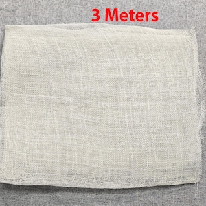 May include: A white ceramic mug with a black handle and the text "But First, Coffee" in a handwritten style. The mug is on a white surface. The mug is 4 inches tall.