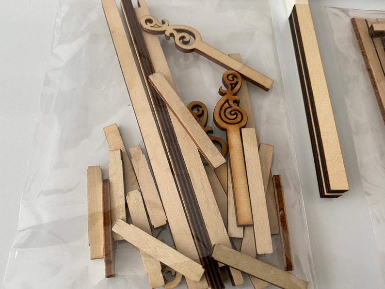 Puede incluir: Un conjunto de piezas de madera para manualidades para construir un modelo. Las piezas son de varias formas y tama&ntilde;os, incluyendo tiras largas, cuadrados cortos y elementos decorativos. Las piezas est&aacute;n hechas de madera de color claro.
