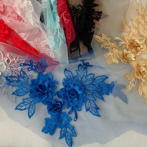 Könnte beinhalten: Sortiment an floralen Spitzenapplikationen in verschiedenen Farben, darunter Gold, Blau und Silber. Die Applikationen zeigen zarte florale Designs mit filigranen Details.