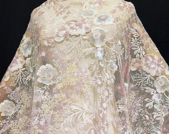 May include: Sheer fabric with floral embroidery and sequin embellishments. The fabric features a delicate pattern of embroidered flowers in pastel shades of pink, blue, and cream, with shimmering sequins scattered throughout. Ideal for bridal wear or special occasion garments.