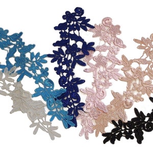 Könnte beinhalten: Fünf Stücke Spitzenbesatz in verschiedenen Farben: Weiß, Hellblau, Dunkelblau, Rosa und Schwarz. Jedes Stück hat ein florales Design mit filigranen Details.