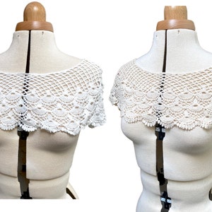 May include: White crochet lace collar with a scalloped edge. The collar is displayed on a white dress form.