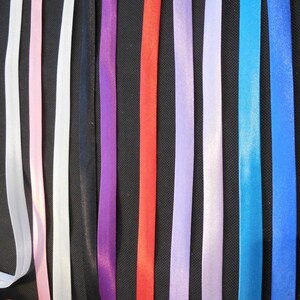 Puede incluir: Surtido de 10 cintas de raso de diferentes colores. Las cintas tienen todas el mismo ancho y est&aacute;n dispuestas en una fila de izquierda a derecha. Los colores son blanco, rosa, negro, morado, rojo, morado claro, blanco, azul, azul verdoso y azul.
