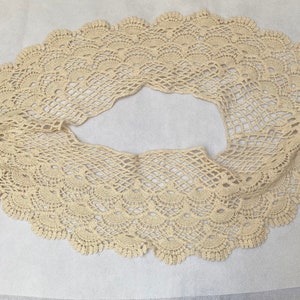 May include: A cream-colored crocheted lace trim with a scalloped edge.