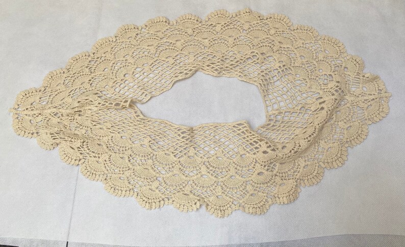 May include: A cream-colored crocheted lace trim with a scalloped edge.