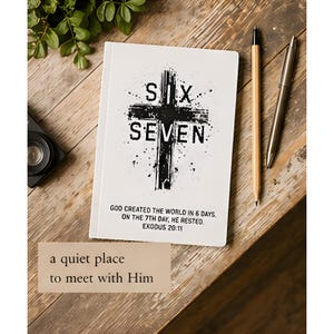 以下が含まれることがあります： 「SIX SEVEN」の文字と十字架のデザインが施された白いノート。テキスト「GOD CREATED THE WORLD IN 6 DAYS. ON THE 7TH DAY, HE RESTED. EXODUS 20:11」が下に印刷されています。鉛筆、ペン、そして「a quiet place to meet with Him」の文字も見えます。