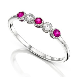 May include: A silver band ring with five gemstones. The ring has three ruby gemstones and two diamond gemstones.