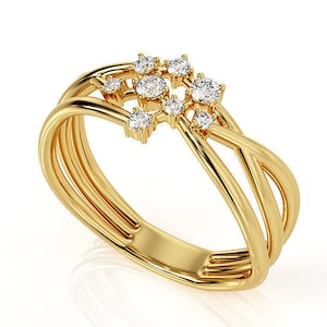 Könnte beinhalten: Ein goldener Ring mit einem zarten, ineinander verschlungenen Banddesign. Der Ring ist mit einem Cluster aus kleinen, funkelnden Diamanten verziert.