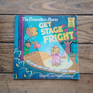 May include: A children's book titled "The Berenstain Bears Get Stage Fright." The cover shows illustrations of bear characters on a stage, with the title in large, colourful letters. The book is a "First Time Books" edition.