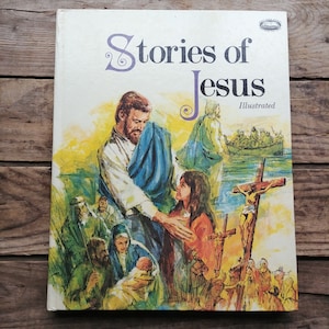 Peut inclure: Un livre pour enfants illustré vintage intitulé "Stories of Jesus". La couverture présente une illustration colorée de Jésus avec une jeune fille et un bébé. Le livre est en bon état avec un léger jaunissement des pages.