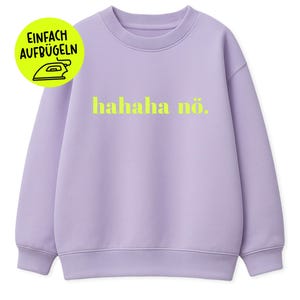 Puede incluir: Una sudadera lila con la frase "hahaha nö." en amarillo brillante. Una pegatina circular en la esquina superior izquierda dice "EINFACH AUFBÜGELN" con un símbolo de plancha. La sudadera tiene cuello redondo y puños y dobladillo acanalados.