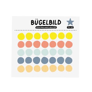 Op de afbeelding: Een vel strijkapplicaties met kleurrijke stippen in geel, koraal, lichtblauw, blauw en perzik. De tekst "BÜGELBILD" staat bovenaan, met het websiteadres "WWW.PAULUNDCLARA.COM" eronder. Een ster en de woorden "TRY ME!" zijn ook aanwezig.