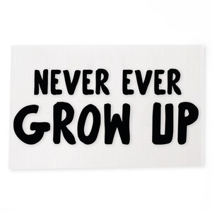 Op de afbeelding: Een wit rechthoekig bord met de tekst "NEVER EVER GROW UP" in dikke, zwarte letters. Het bord is een decoratief item, geschikt voor een slaapkamer of speelkamer.