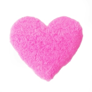 Könnte beinhalten: Ein flauschiges, hellrosa herzförmiges Objekt. Das Herz hat ein weiches, strukturiertes Aussehen, wobei sichtbare Fasern einen plüschigen Effekt erzeugen. Der Hintergrund ist schlicht weiß, wodurch die leuchtende Farbe und Form des Herzens betont werden.