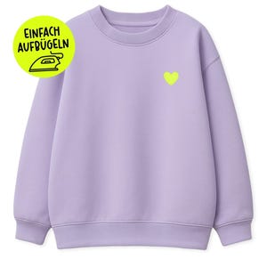 Puede incluir: Una sudadera de color lila con un corazón amarillo neón en el pecho izquierdo. La sudadera tiene cuello redondo y puños y dobladillo acanalados. Un gráfico circular amarillo y verde con el texto "EINFACH AUFBUGLEN" está en la parte superior izquierda.