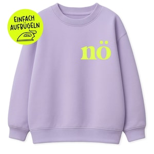 Op de afbeelding: Een lila sweatshirt met het woord "nö" in neongeel op de voorkant. Een cirkelvormige afbeelding met de tekst "EINFACH AUFBÜGELN" en een strijkijzerpictogram staat linksboven. De sweatshirt heeft een ronde hals en geribde manchetten en zoom.
