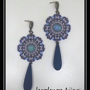May include: A pair of dangle earrings with a blue, white, and purple beaded flower design and a dark blue teardrop pendant. The earrings are accented with a small iridescent blue stone in the center of each flower.