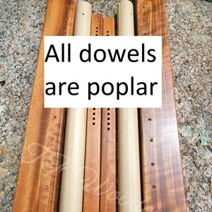 May include: A set of wooden dowels and wooden slats, all in shades of brown. The dowels are light brown and the slats are a darker brown with a reddish hue. The text "All dowels are poplar" is printed on a white background.