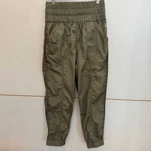 Pu&ograve; includere: Pantaloni cargo verde oliva con vita a coulisse e gambe a polsino.